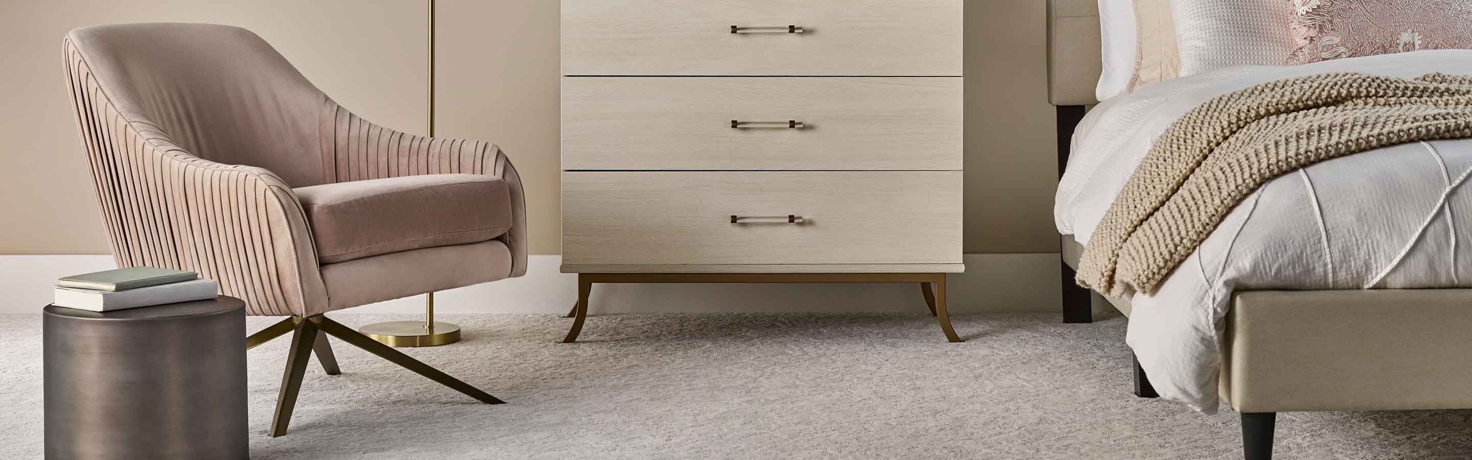 beige textured carpet in contemporary bedroom with blush pink and red accents, fluted chair and dresser