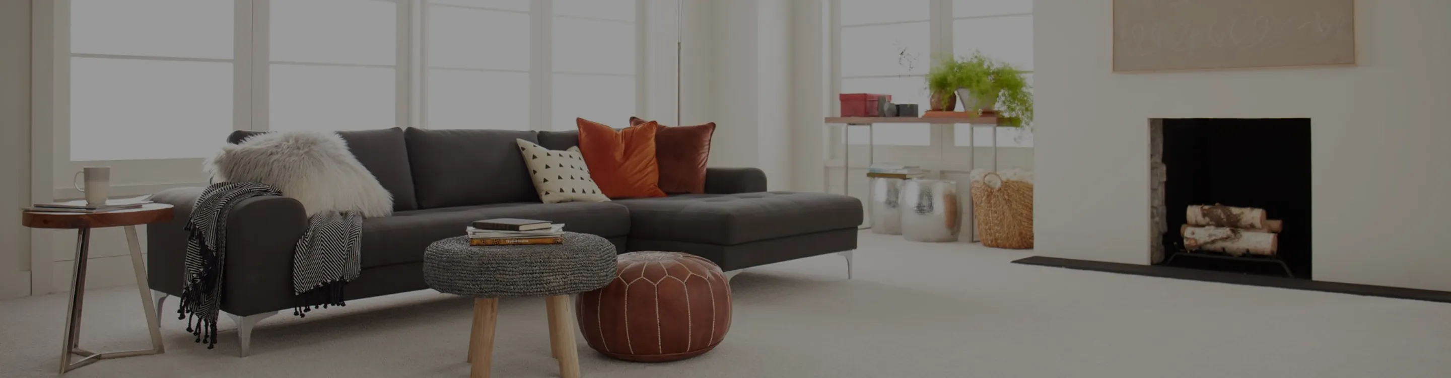 Living room with brown couch and two chairs, beige carpet
